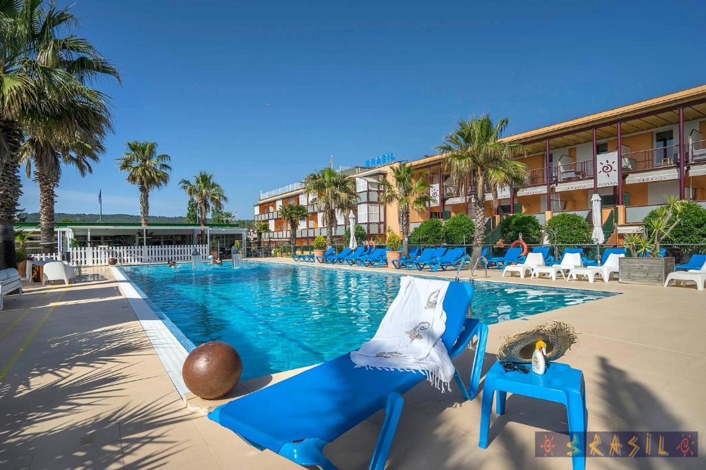 埃斯塔蒂特Apartamentos Brasil - Viu Bé的一个带蓝色椅子的游泳池和一间酒店