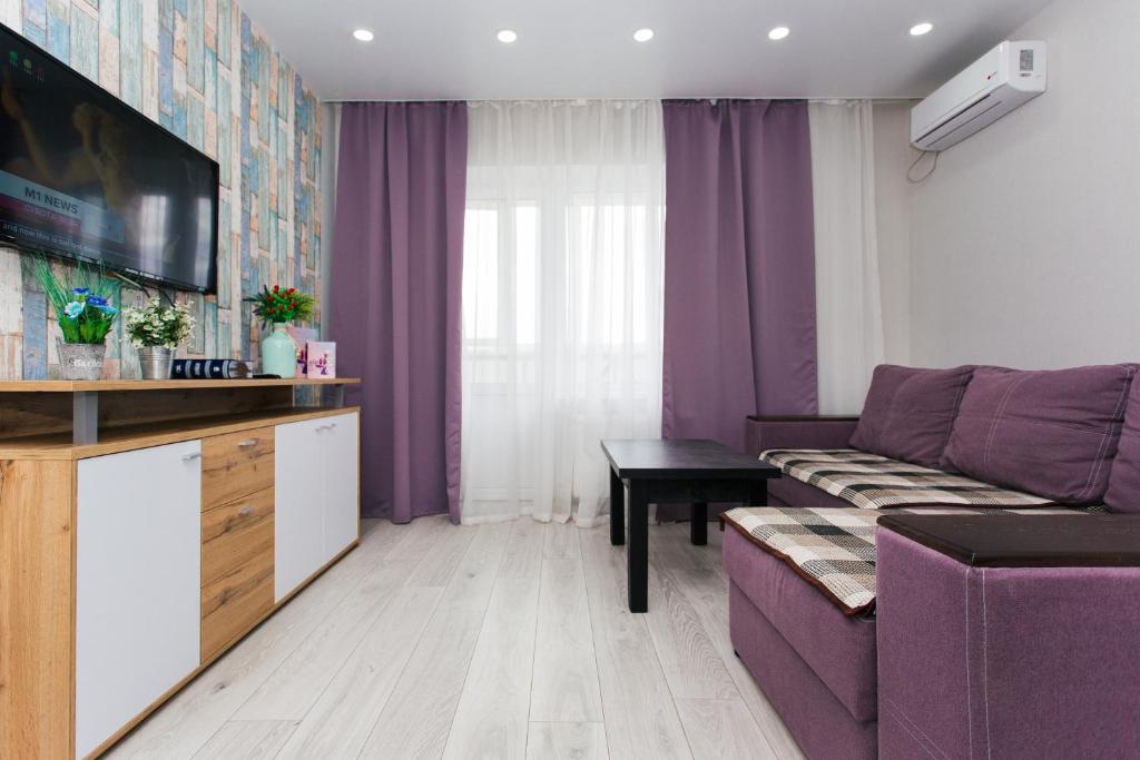 苏梅VIP Apartments Faraon Centr的客厅配有紫色沙发和桌子