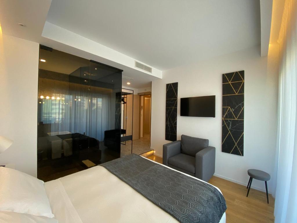 佩斯卡拉MYHOME 75 Premium Luxury B&B的一间卧室配有一张床和一把椅子