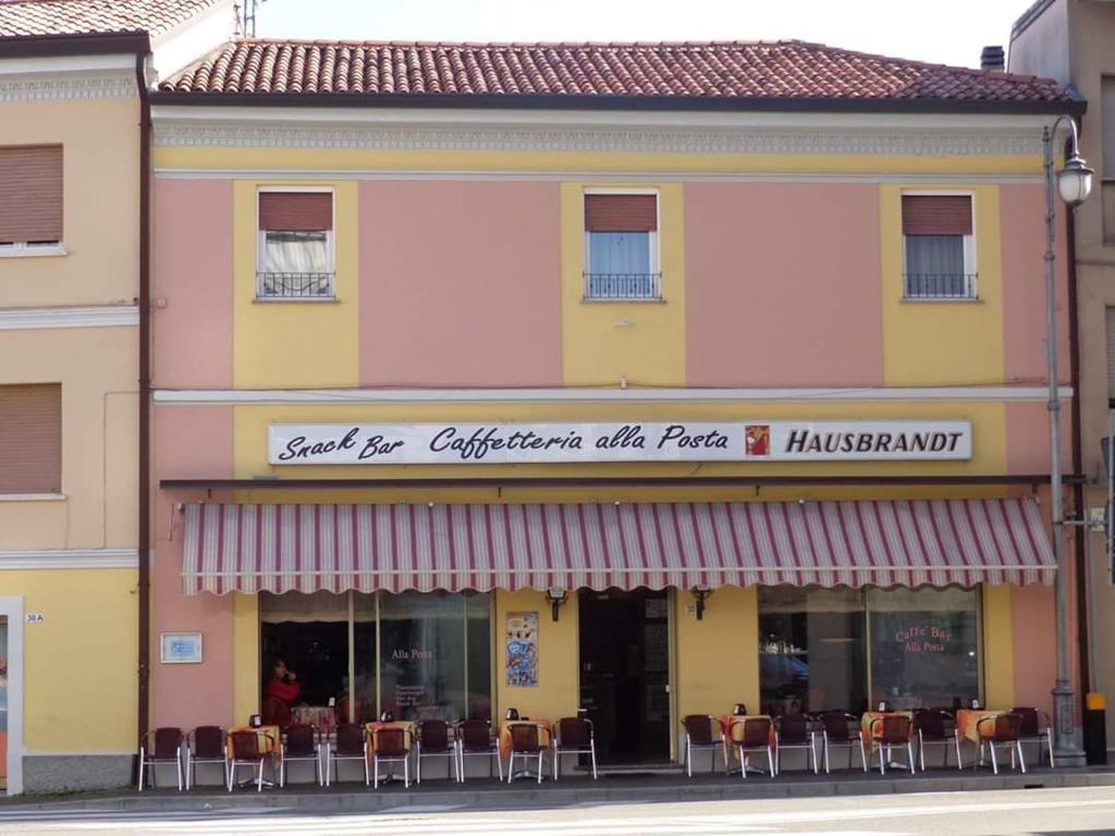 圣焦尔焦迪诺加罗Hotel Affittacamere alla Posta的大楼前设有桌椅的餐厅