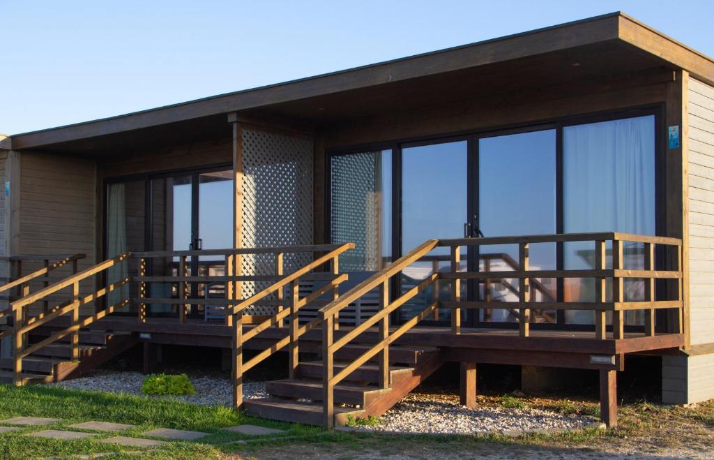 佩尼契PenichePraia - Bungalows, Campers & SPA的房屋设有大型甲板和玻璃窗