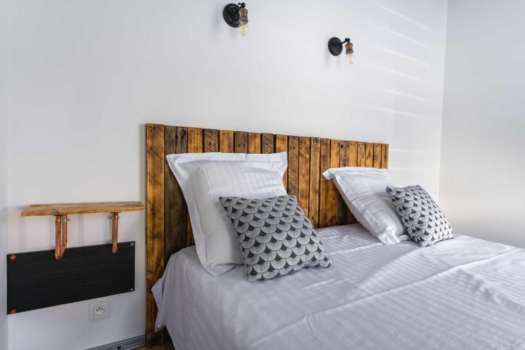 卢维耶La Dimiere - Le Postel - Appartements de standing en hyper-centre - Louviers的一间卧室配有带白色床单和枕头的床。