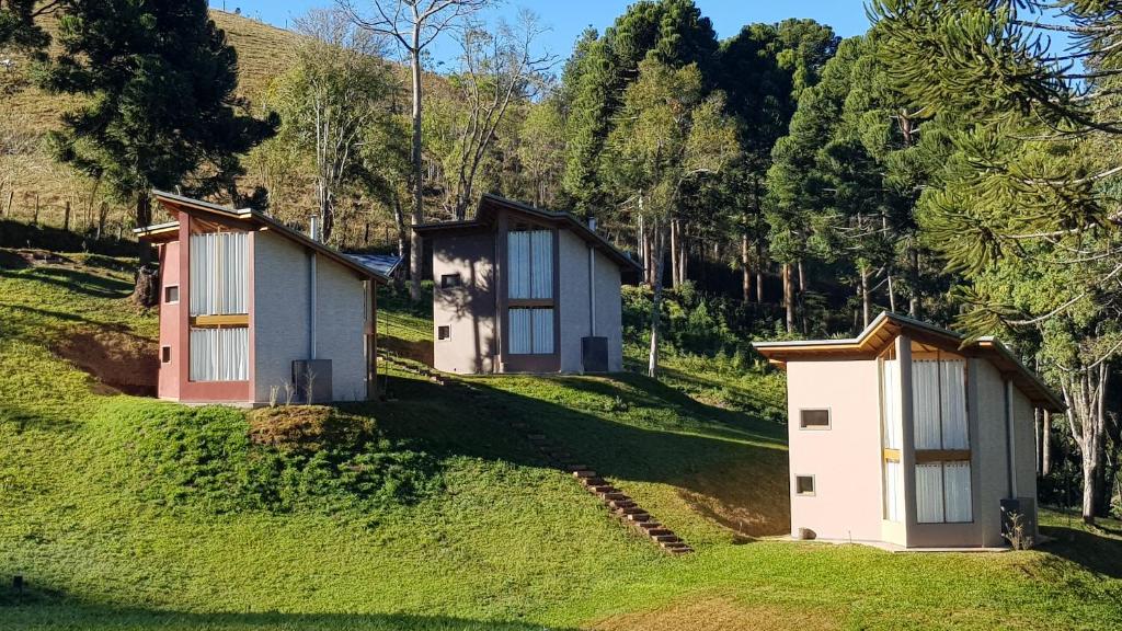 蒙特韦尔迪Robinson Cottage Monte Verde MG的两座树荫小山上的小房子
