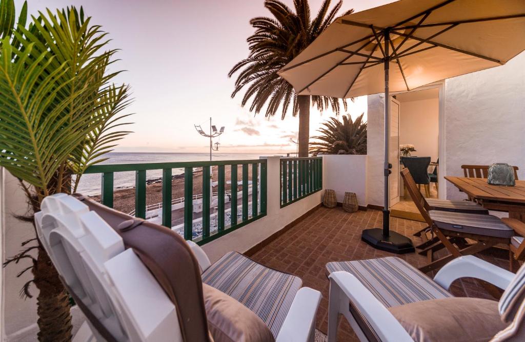 宏达海滩Luxury Suite Sea Front的一个带椅子和遮阳伞的阳台,并享有海景。