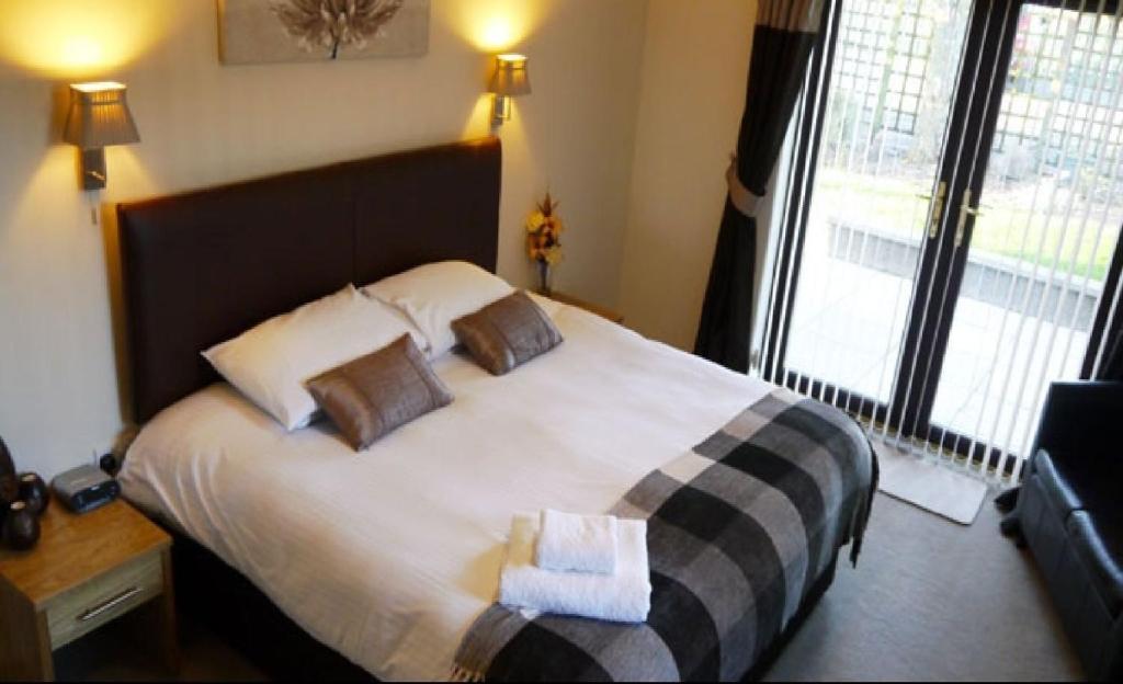 CairnessBan-Car Hotel的一间卧室配有一张大床和两个枕头