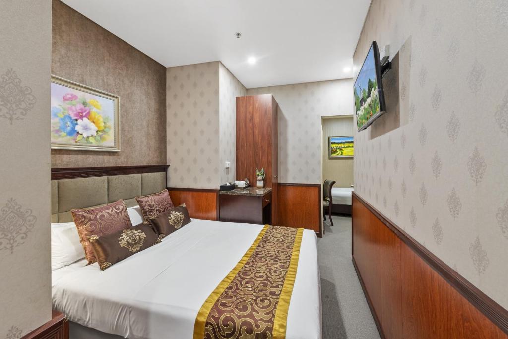 悉尼YEHS Hotel Sydney CBD的一间酒店客房,配有一张床和一台电视