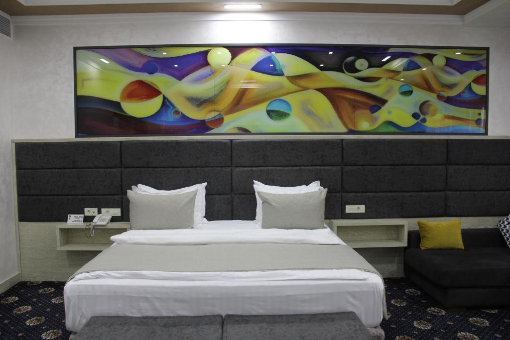 埃里温埃瑞布尼埃里温酒店的酒店客房设有两张床,墙上挂有绘画作品