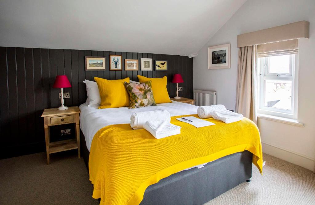 伯翰姆昂斯邓斯坦大楼酒店的一间卧室配有黄色的床和毛巾
