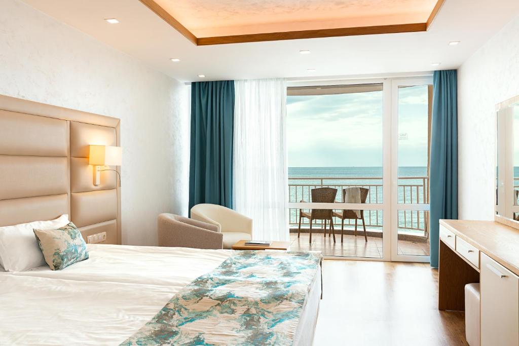 内塞伯尔Bilyana Beach Hotel - All Inclusive & Free Beach Access的酒店客房设有一张床,享有海景。