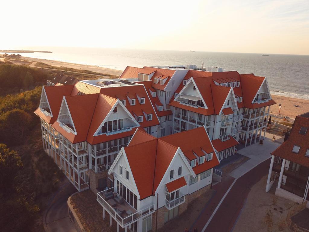 卡德赞德Familie beachhuis op de duinen (Duinhuis)的享有带橙色屋顶的建筑的空中景致