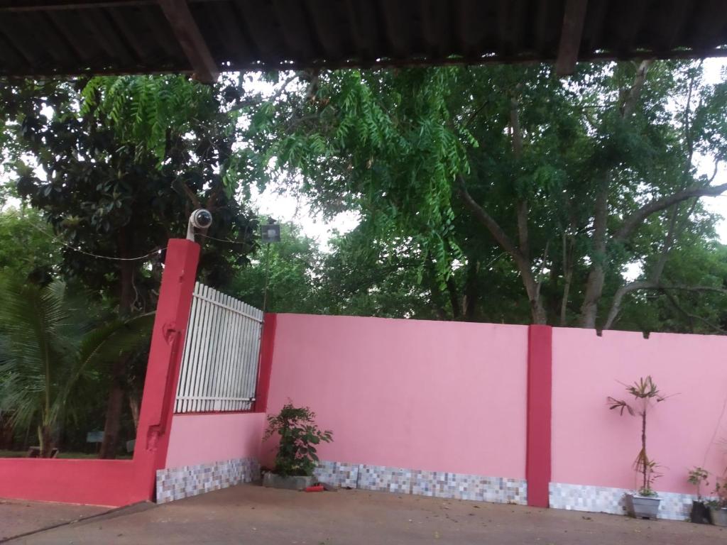 伊瓜苏pousadavaledasaguas的粉红色的围栏,有树在后面