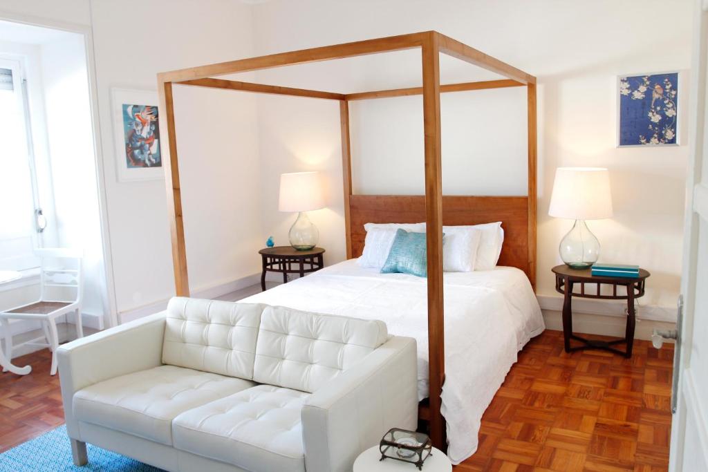 里斯本马格诺利娅住宿加早餐旅馆的白色卧室设有天蓬床和白色沙发