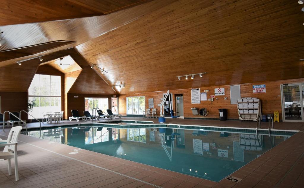姐妹湾Pheasant Park Resort的一座大型游泳池,位于一座拥有木制天花板的建筑中