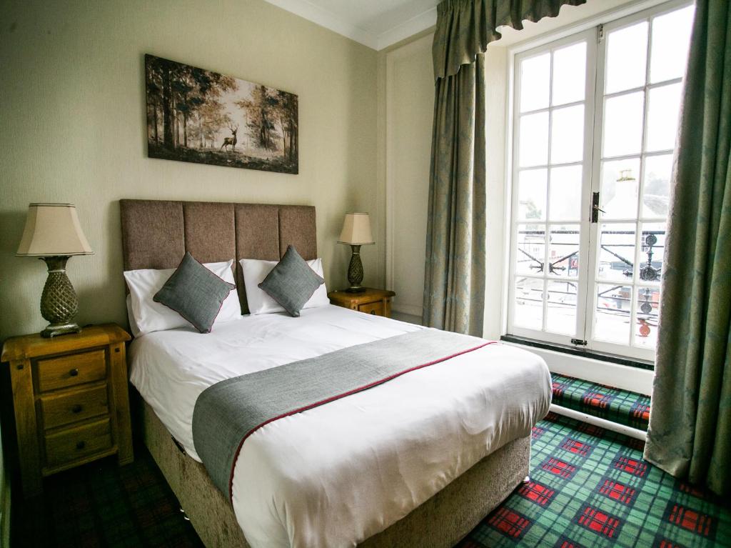 丁沃尔The National Hotel的一间卧室设有一张床和一个大窗户