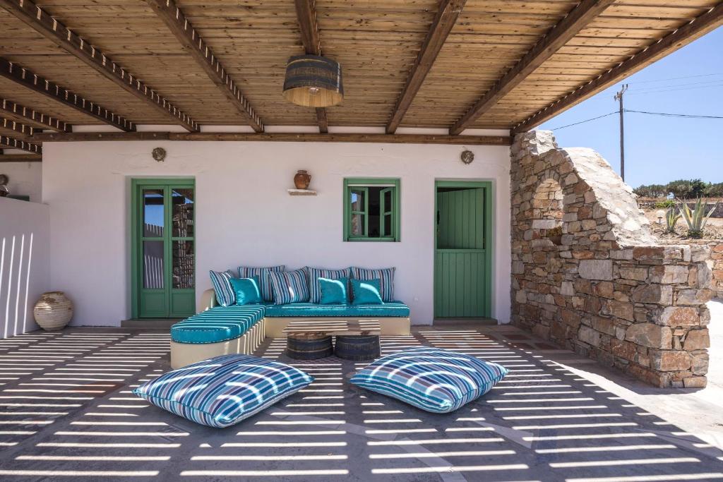 斯希努萨岛Ailouros Scenic Guest Houses的一个带蓝色沙发和木制天花板的庭院