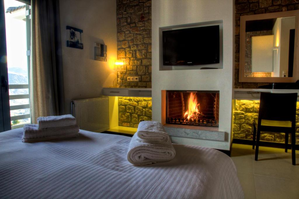 卡托卡拉库林斯狄俄库里旅馆的一间卧室配有一张带毛巾的床和壁炉