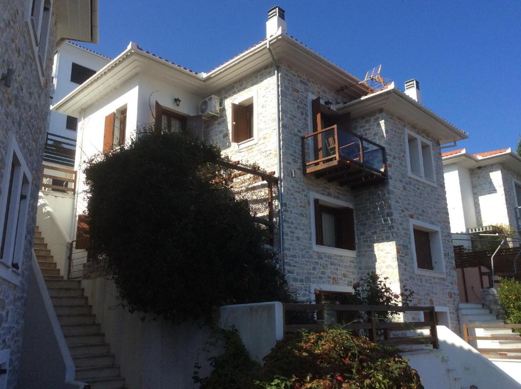 阿吉奥斯伊欧尼斯AUTUMN TO SUMMER的白色砖屋,设有阳台和楼梯