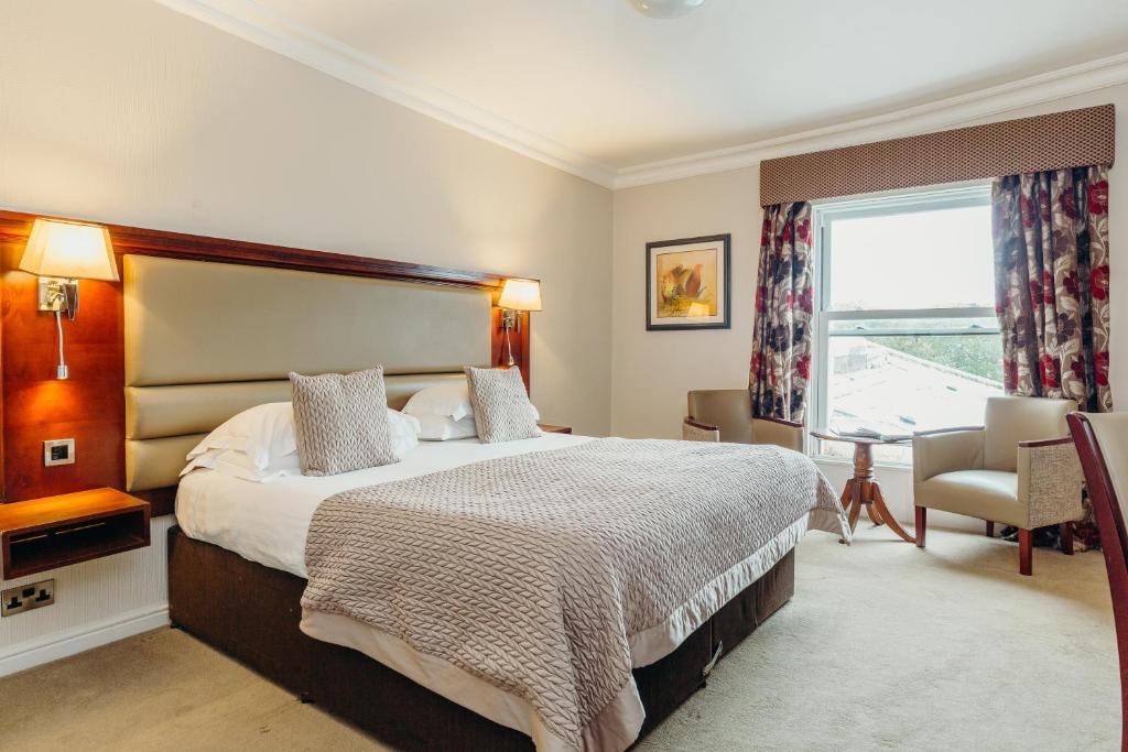 斯卡伯勒斯卡伯勒康帕斯皇冠Spa酒店的一间卧室设有一张大床和一个窗户。