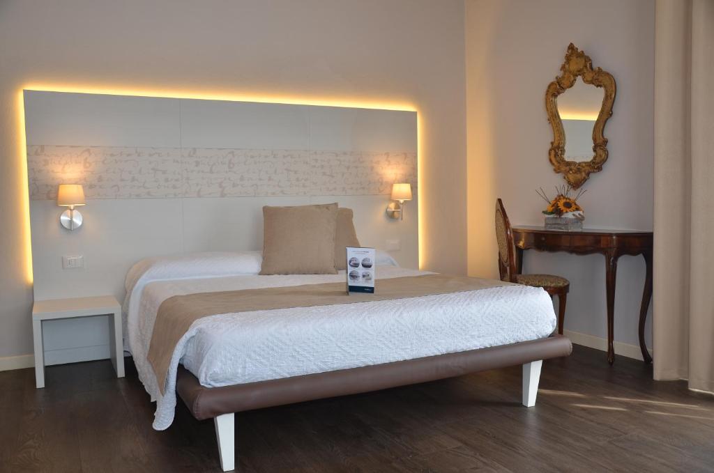 西尔米奥奈H2o住宿加早餐旅馆的卧室配有一张床,墙上设有镜子