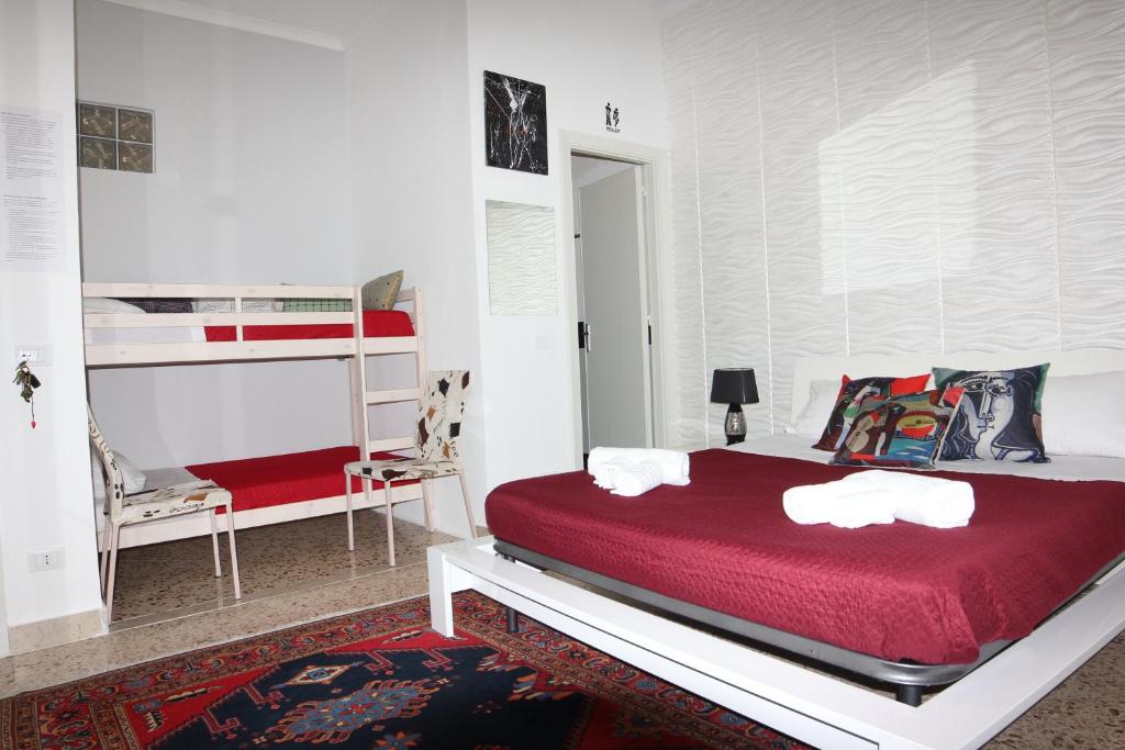 特拉帕尼B&B Il Profumo del Porto的一间卧室配有红色的床和一张双层床。