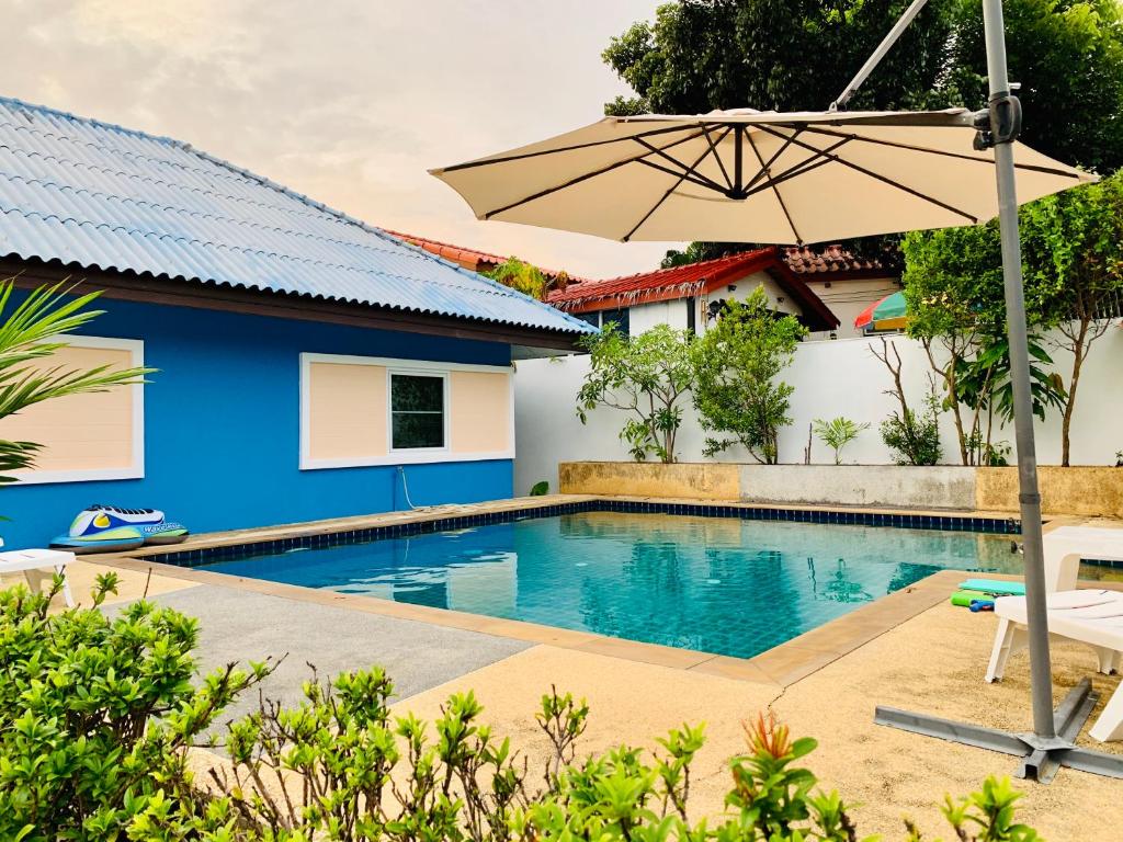 Ban SuanNai Harn 4 Resort的一座房子旁带遮阳伞的游泳池