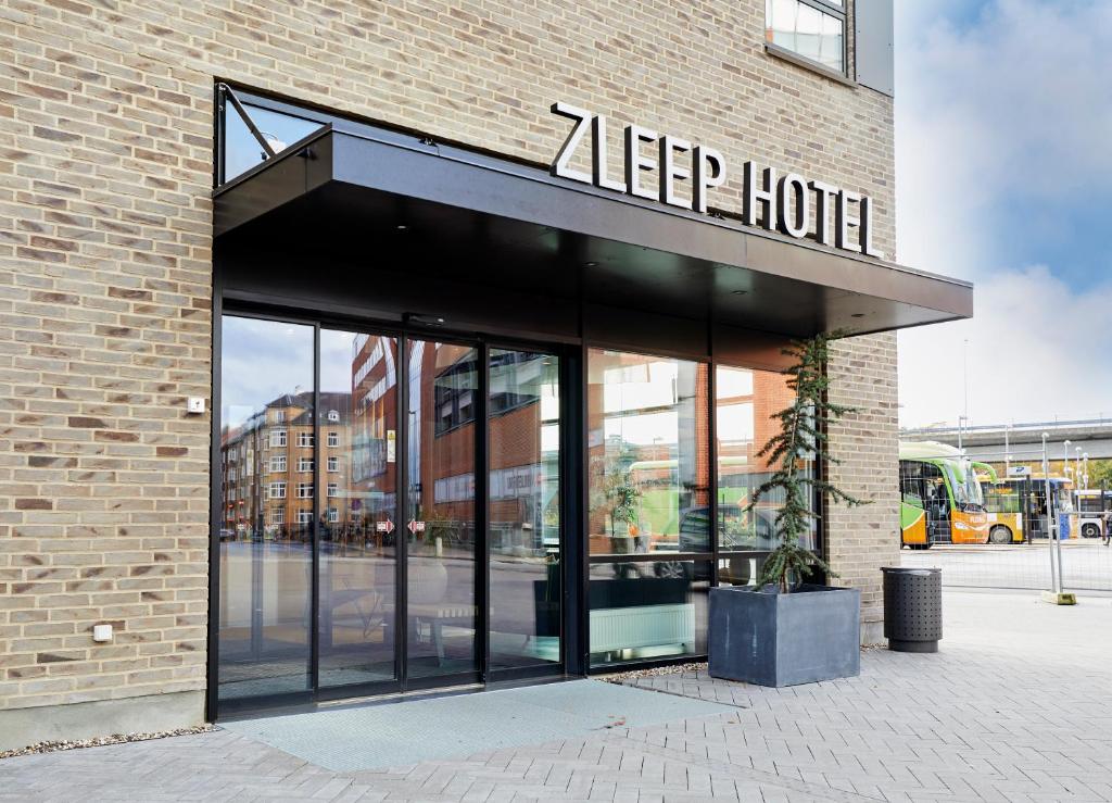 奥尔堡Zleep Hotel Aalborg的一座建筑,上面有读物的标志,可以改变酒店