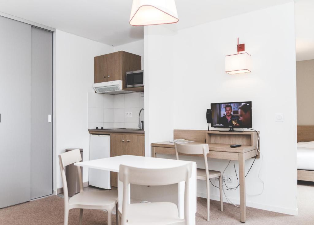 坎佩尔法国之地 - 坎佩尔布列塔尼公寓式酒店 的厨房以及带桌椅的用餐室。