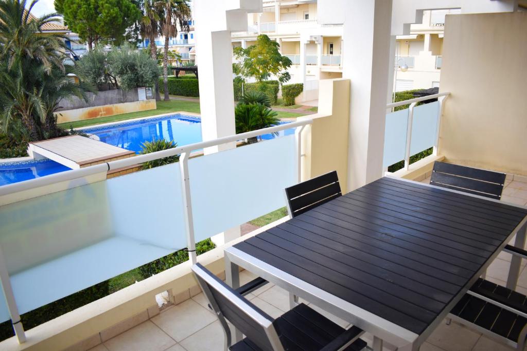 奥利瓦Anacasa Vora Golf 3 Playa Rabdells DUP3027的一个带桌椅的阳台和一个游泳池