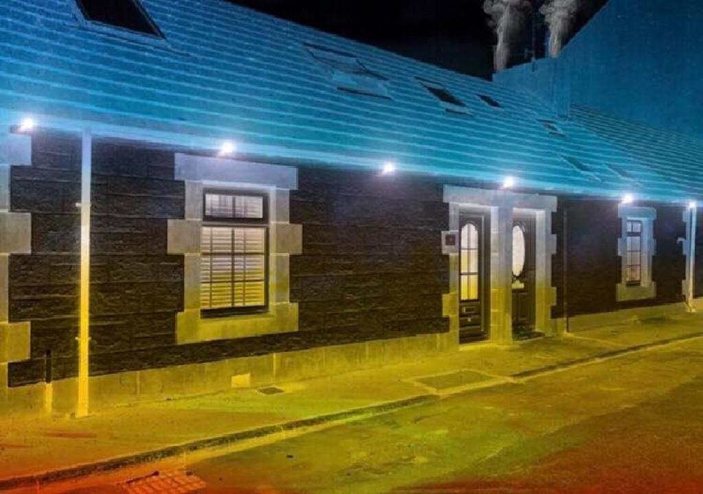 格文Ayrshire Holiday Cottage的街上的砖砌建筑,晚上有灯