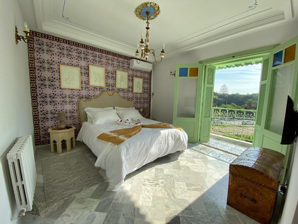 拉马萨Dar El Kif - La Marsa的一间卧室设有一张床和一个大窗户