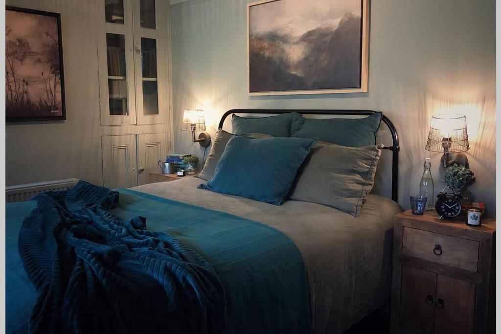 卡纳芬CELYN - SNOWDONIA COTTAGE的一间卧室配有一张带蓝色床单和枕头的床。