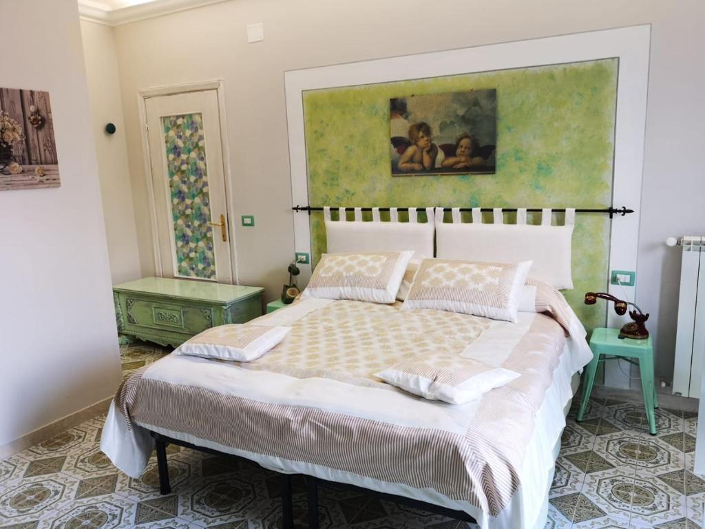 博尔塞纳B&B L ORTENSIA的卧室配有一张床,墙上挂有绘画作品