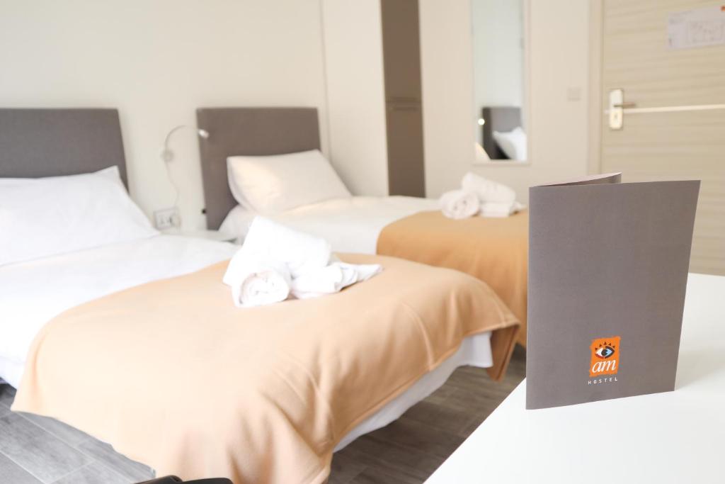 斯利马AM Hostel的两张位于酒店客房的床,配有毛巾