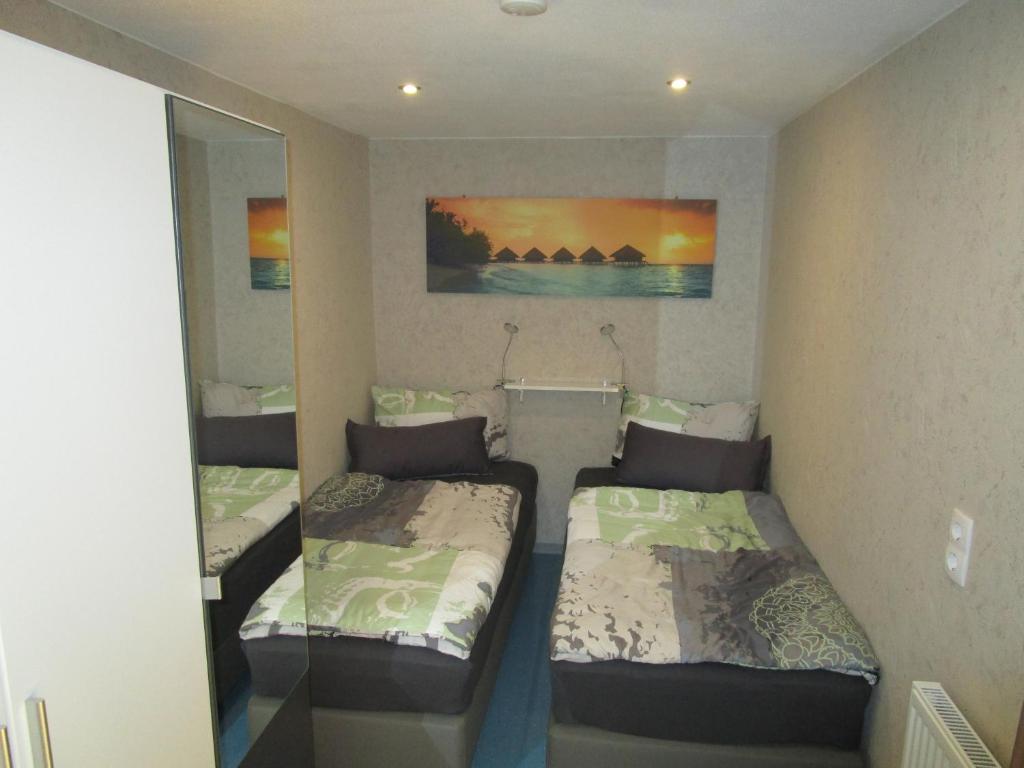 布伦瑞克Übernachtung an der A2的小型客房的两张床,配有镜子