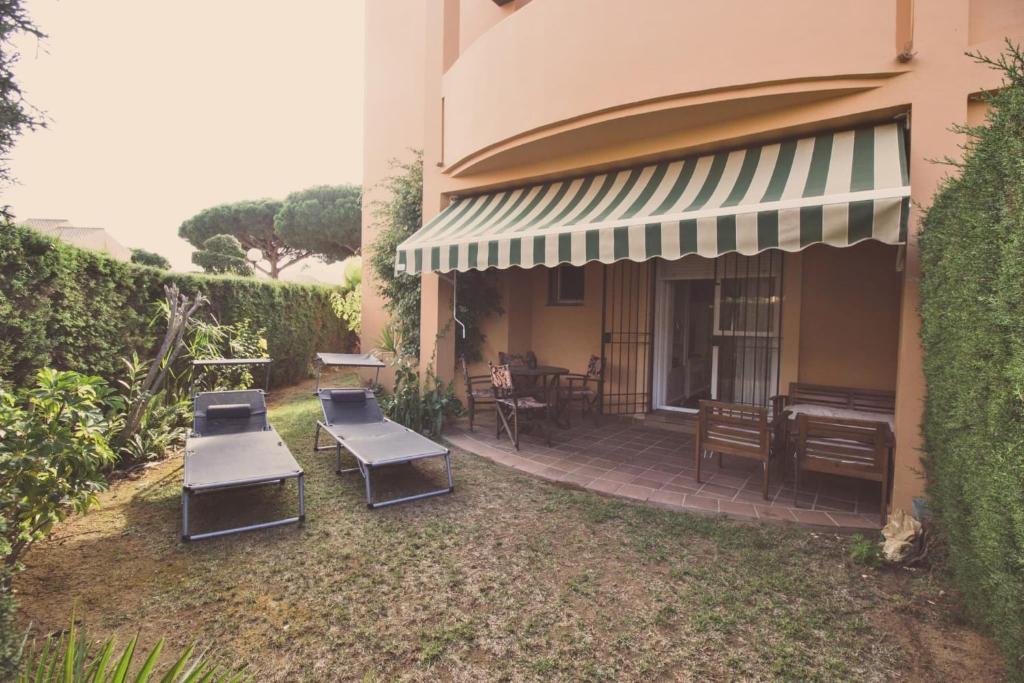 奇克拉纳－德拉弗龙特拉Apartamento Jardín del golf 2的一个带桌椅和钢琴的庭院