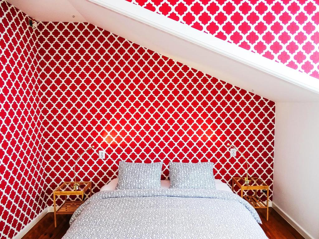 波尔图SUPERNOVA - Hostel & Café的一间卧室配有红色图案的墙壁和一张床