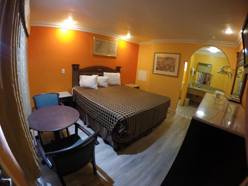 安纳海姆Calico Motel的酒店客房配有一张床铺和一张桌子。