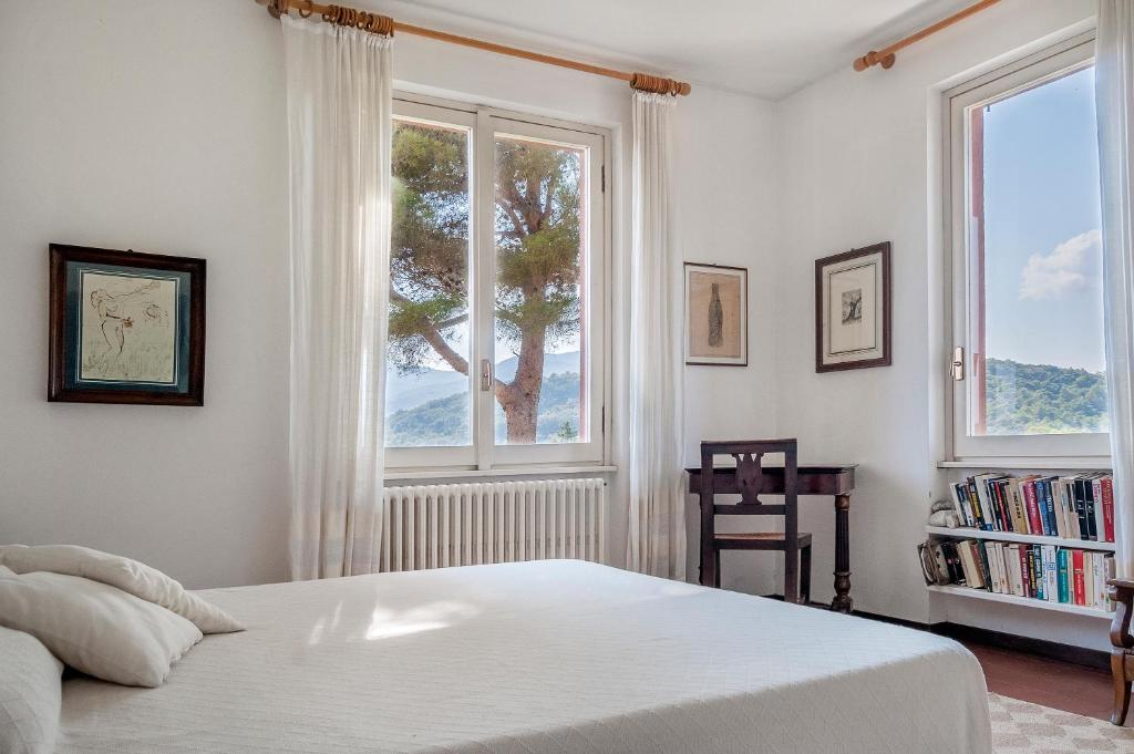 费拉约港Il Grifo - Cozy house, wonderful view的卧室设有一张白色大床和两个窗户。