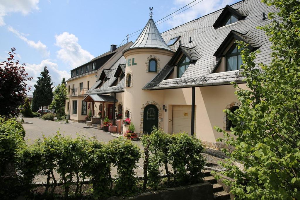 OberahrLandhotel Villa Moritz garni的一座大型黄色房屋,屋顶灰灰色