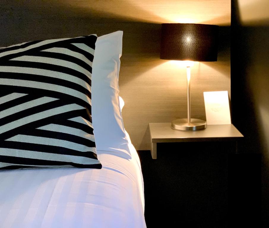 斯昆波特曼旅馆的一张带黑白枕头和灯的床