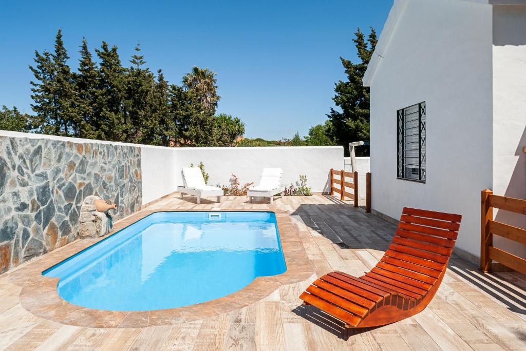 巴尔巴特Casa 3 - Mar y Sol的一座房子旁带一对椅子的游泳池