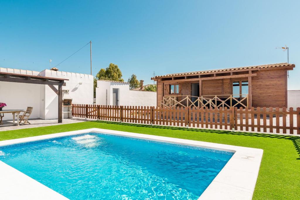 科尼尔-德拉弗龙特拉Casa Hefestión的一座带房子的庭院内的游泳池
