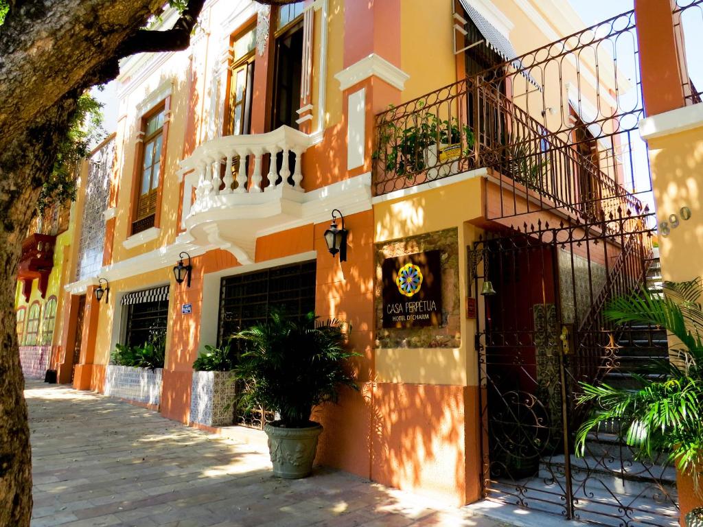 马瑙斯Casa Perpetua Hotel D Charm的黄色和橙色的建筑,设有阳台