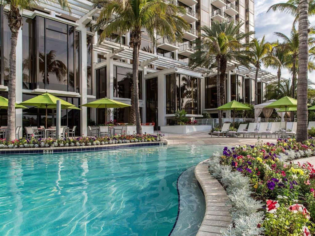 萨拉索塔Hyatt Regency Sarasota的棕榈树建筑前的游泳池