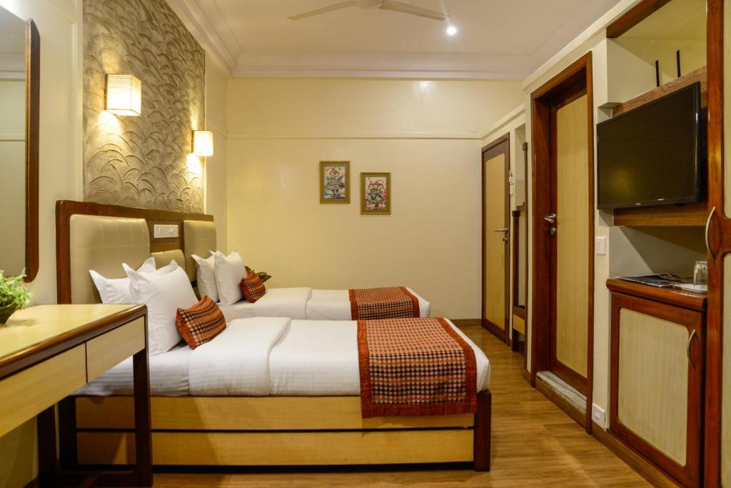 孟买Hotel Ameya的酒店客房,配有床和电视