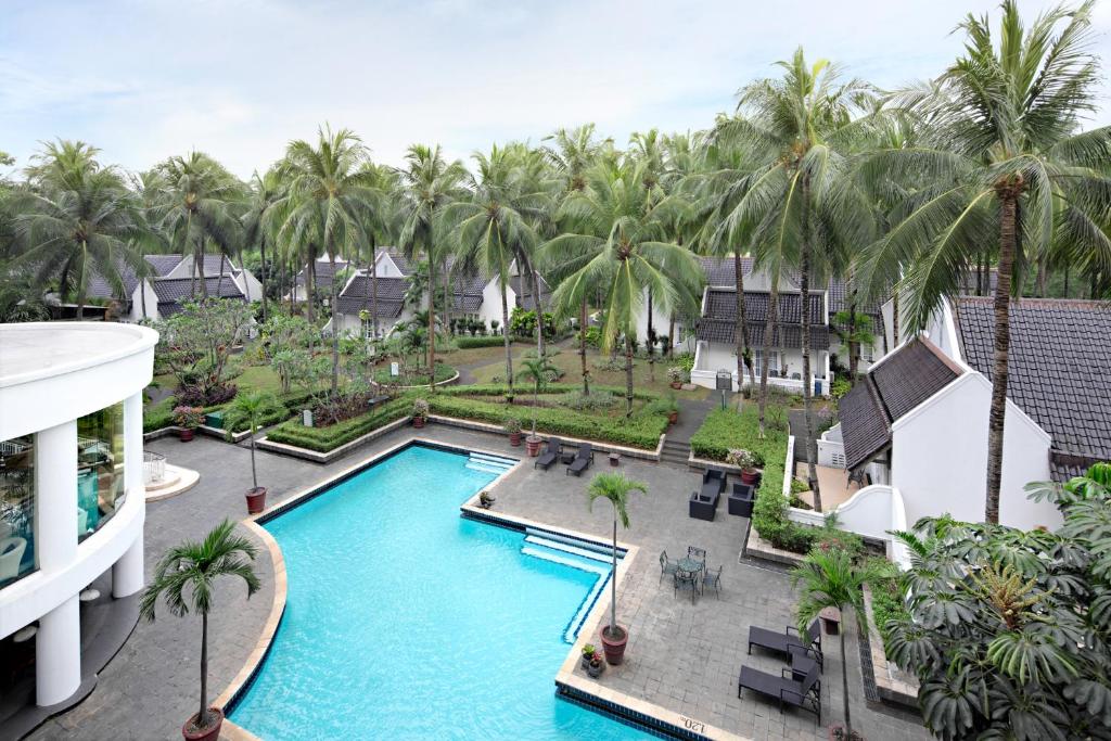 当格浪阿里亚力宝村酒店的享有棕榈树度假村游泳池的空中景致