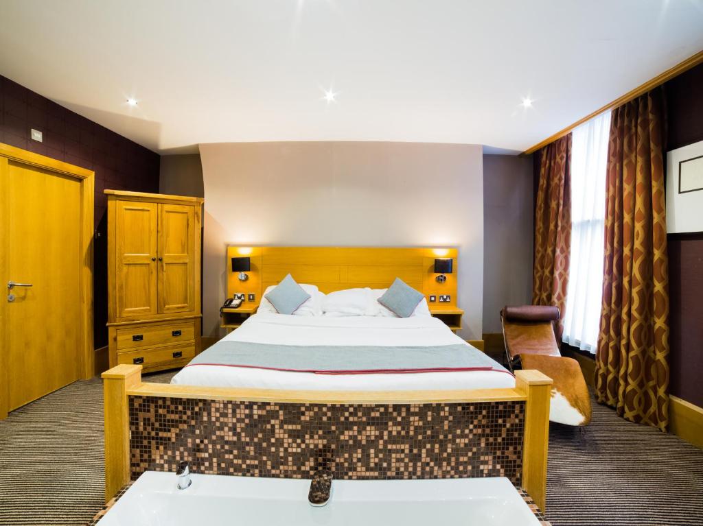 巴罗弗内斯OYO Imperial Hotel的酒店客房配有一张床和浴缸。