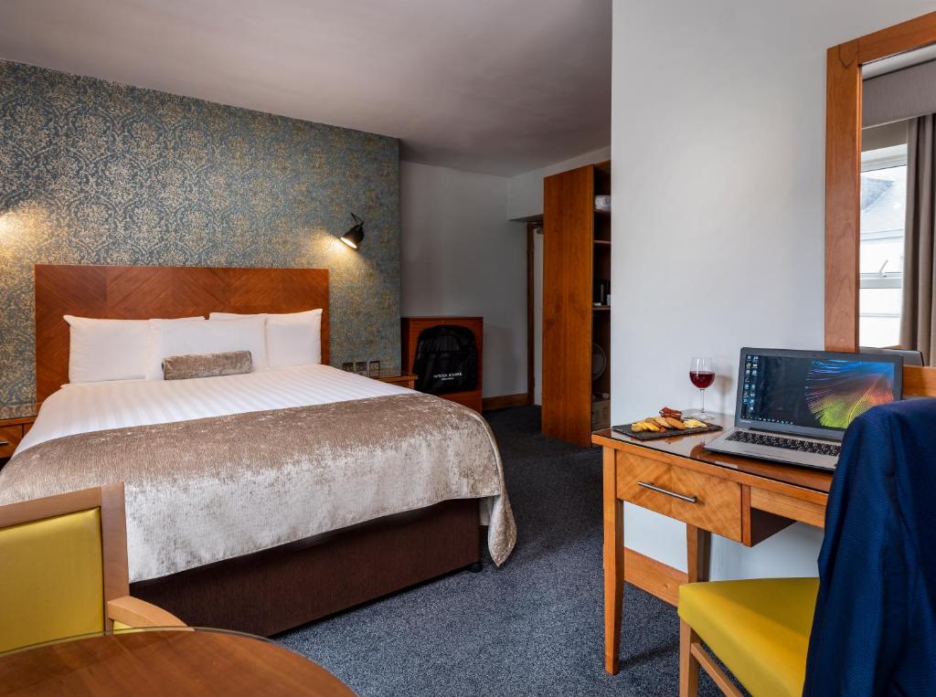 沃特福德沃特福德特里希斯温泉及休闲俱乐部酒店的酒店客房配有一张床、一张书桌和一台笔记本电脑