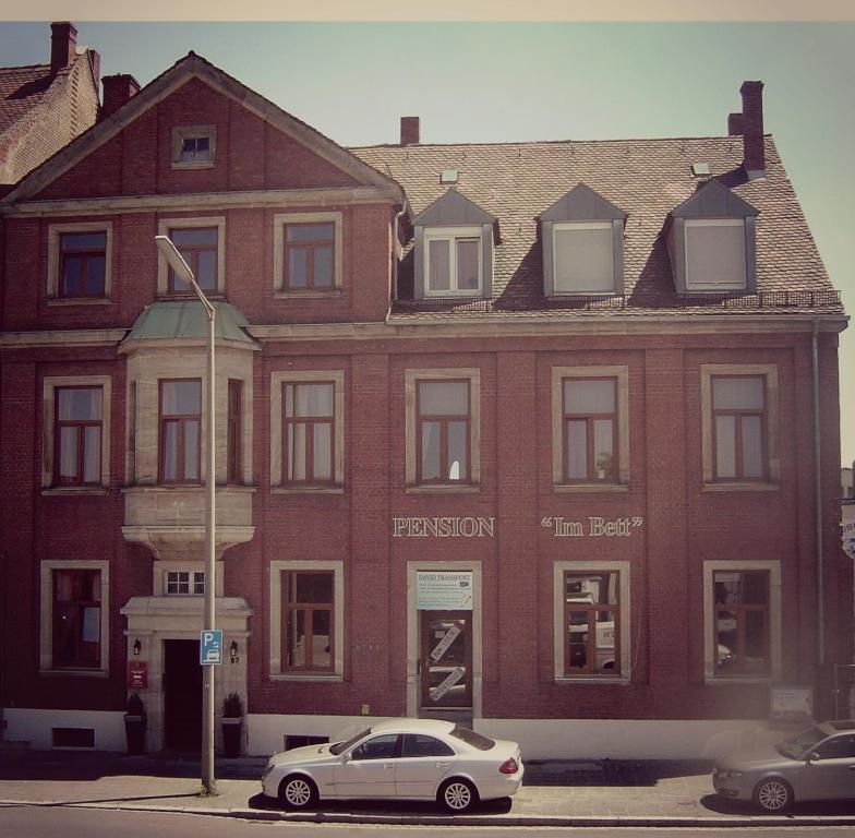 纽伦堡艾姆贝特膳食公寓酒店的停在红砖楼前的白色汽车