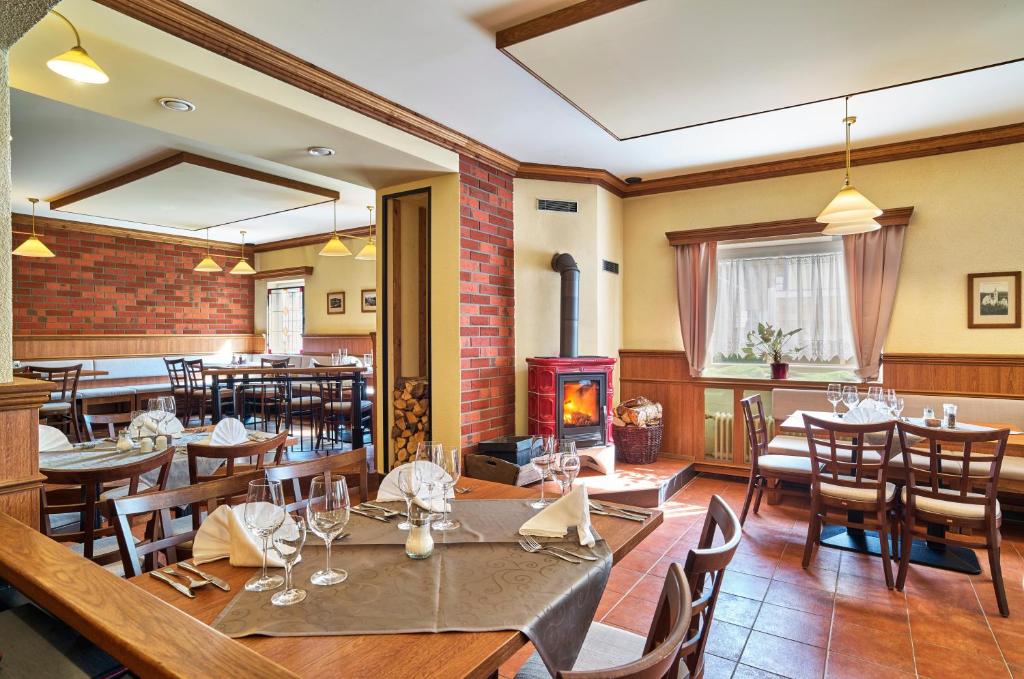 拜尔里舍艾森施泰恩埃森斯特因内霍夫酒店的一间带桌椅和壁炉的餐厅